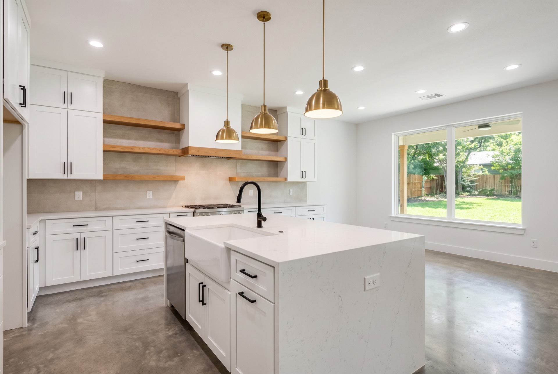The same kitchen after remodeling with white cabinetry and quartz counters